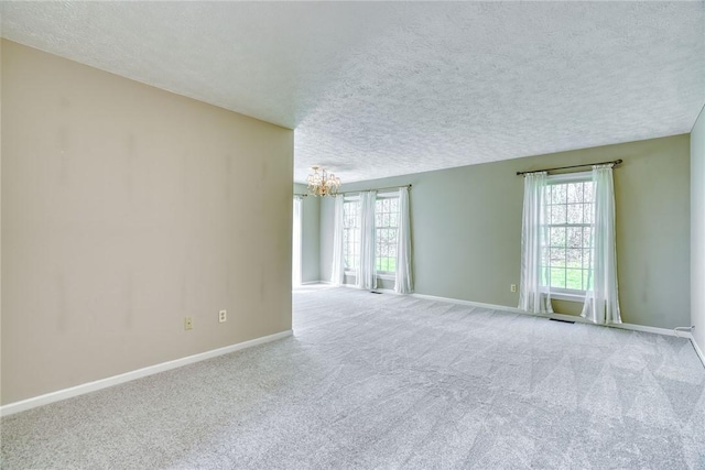 unfurnished room featuring carpet, a textured ceiling, and a healthy amount of sunlight