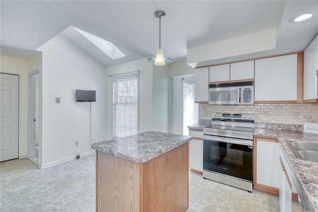 kitchen featuring light floors, decorative backsplash, stainless steel appliances, and white cabinetry