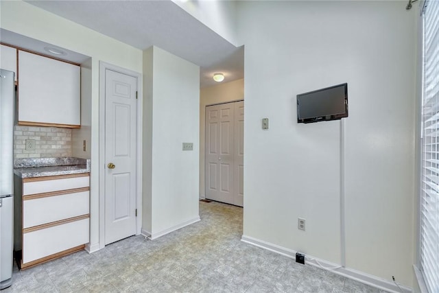 interior space featuring baseboards and light floors