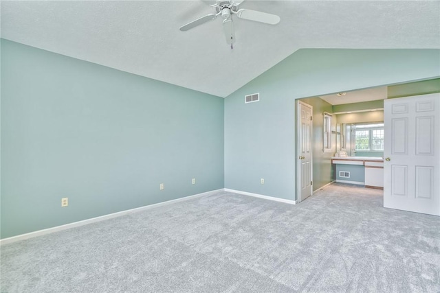 unfurnished bedroom featuring visible vents, a ceiling fan, baseboards, carpet flooring, and vaulted ceiling