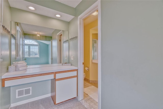 bathroom featuring toilet, baseboards, visible vents, and vanity