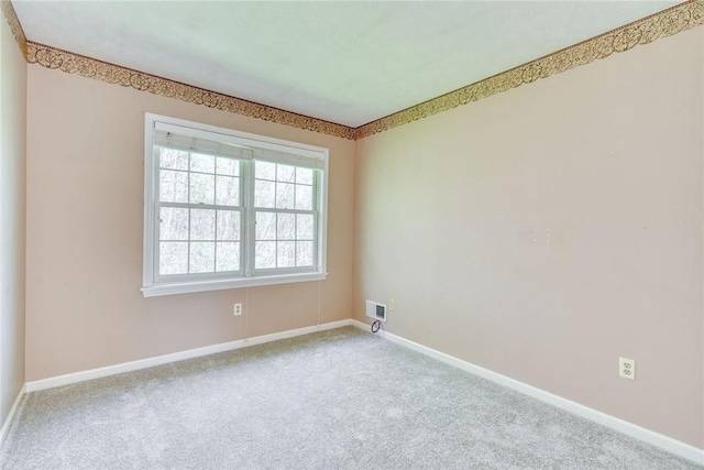carpeted spare room with baseboards and visible vents