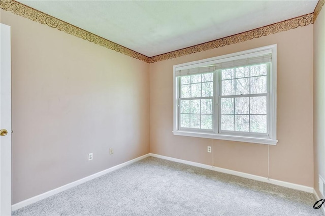 carpeted empty room featuring baseboards