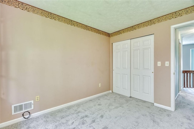 unfurnished bedroom featuring visible vents, baseboards, carpet floors, and a closet