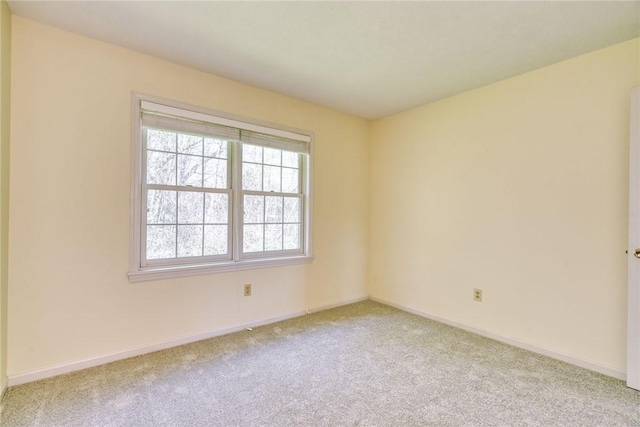 carpeted empty room featuring baseboards