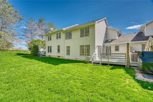 rear view of property featuring a yard and a deck