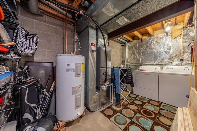 utility room featuring heating unit, washing machine and dryer, and electric water heater