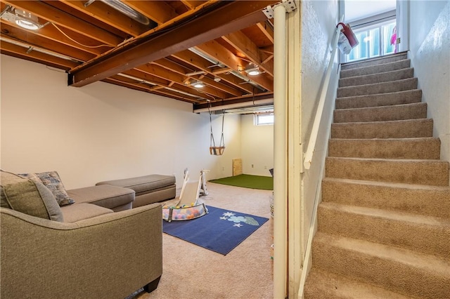 below grade area featuring carpet floors, plenty of natural light, and stairs