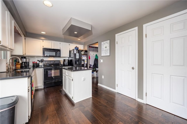 kitchen with dark countertops, a sink, black appliances, and a center island