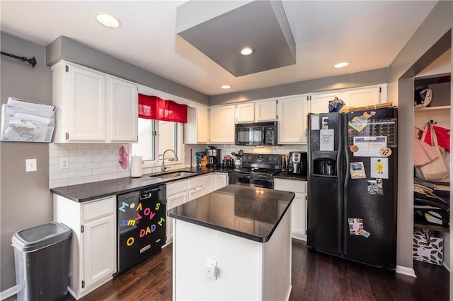 kitchen featuring a sink, white cabinetry, tasteful backsplash, dark wood-style floors, and black appliances