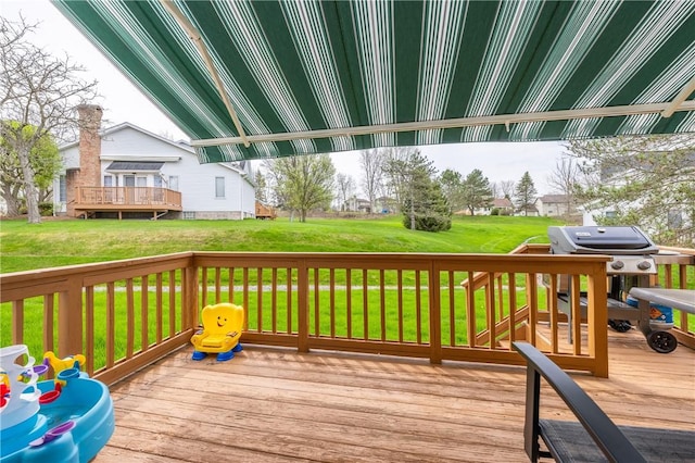 wooden deck with grilling area and a yard