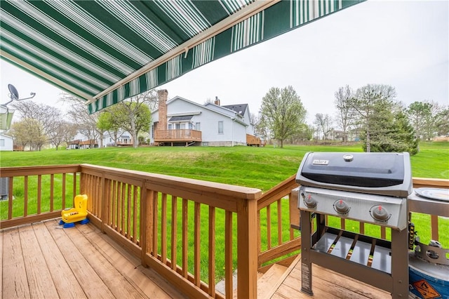 deck featuring a lawn, a residential view, and a grill