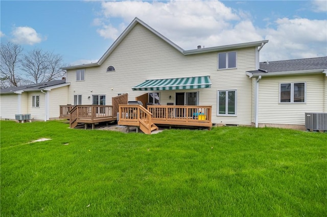 back of house with central air condition unit, a deck, and a yard