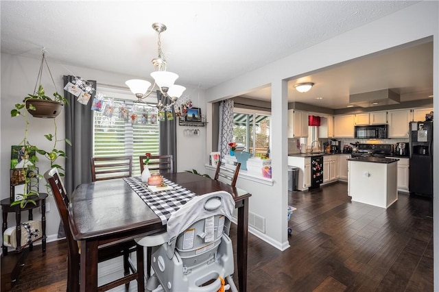dining space with an inviting chandelier, baseboards, dark wood-type flooring, and visible vents