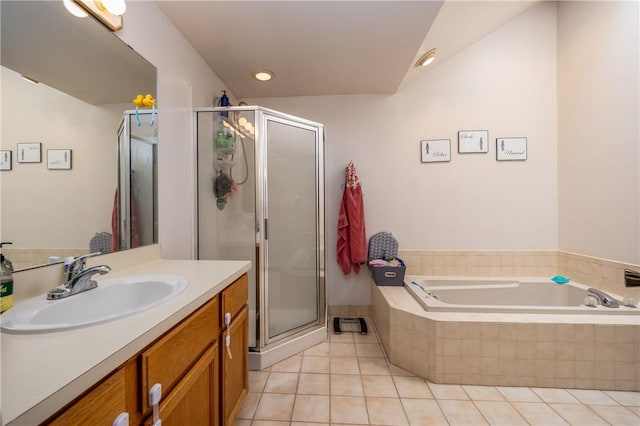bathroom with a bath, a stall shower, tile patterned flooring, and vanity
