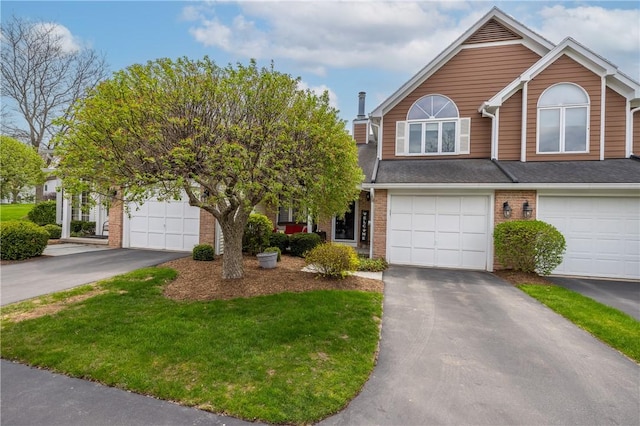 multi unit property with brick siding, a front yard, and aphalt driveway