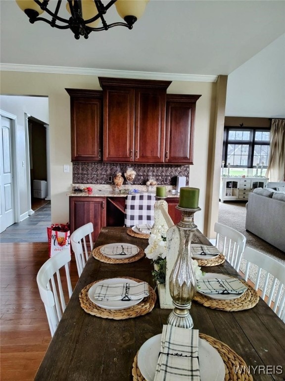 dining room with crown molding, baseboards, dark wood finished floors, and a notable chandelier
