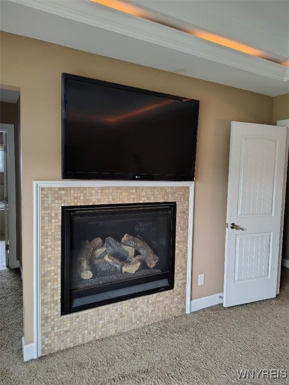 interior details with carpet floors, baseboards, and a tiled fireplace