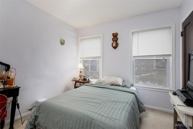 bedroom with baseboards, carpet flooring, and multiple windows
