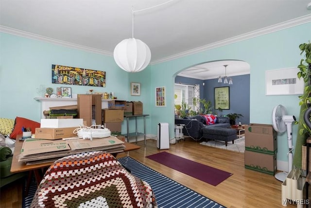 interior space with crown molding, arched walkways, and wood finished floors