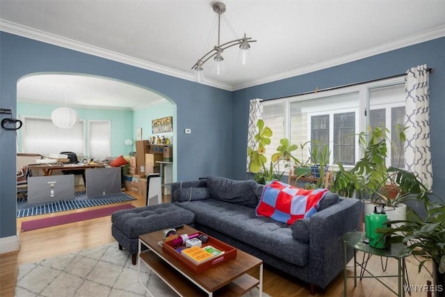 living room with arched walkways, wood finished floors, and ornamental molding