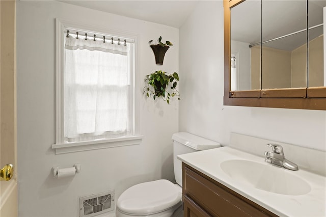 bathroom with vanity, toilet, and visible vents