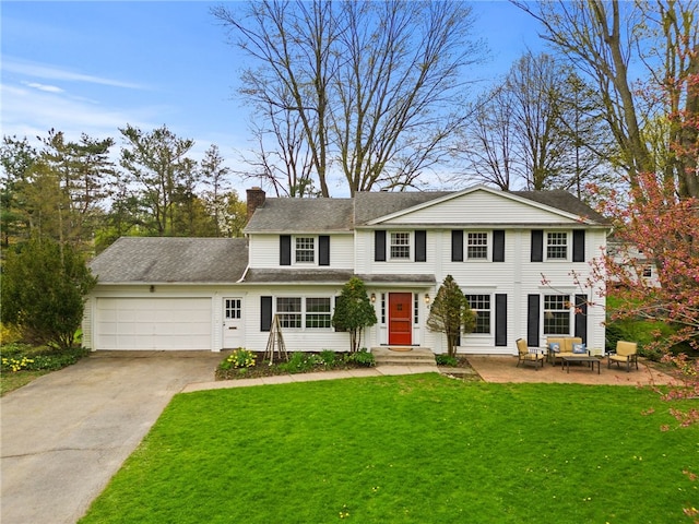 view of front of house with a garage, a chimney, driveway, and a front lawn