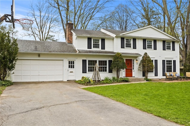 view of front of property with a garage, a chimney, a front lawn, and aphalt driveway