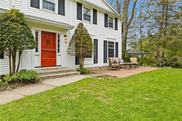 property entrance featuring a patio area and a yard
