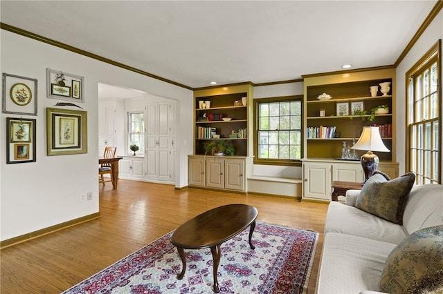 living room featuring light wood-style floors, baseboards, and ornamental molding