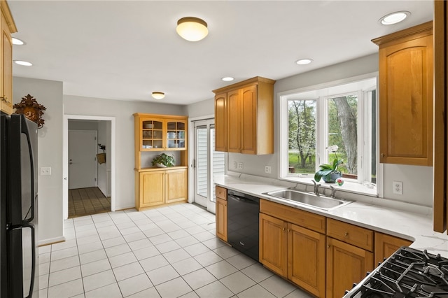 kitchen featuring a sink, light countertops, light tile patterned floors, black appliances, and recessed lighting
