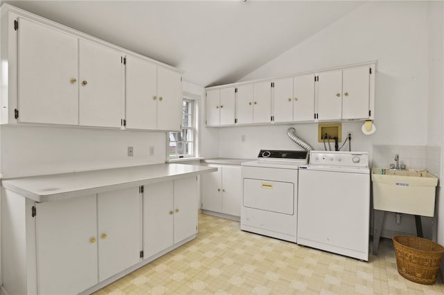 laundry room featuring a sink, light floors, independent washer and dryer, and cabinet space