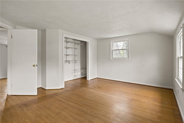 unfurnished bedroom with baseboards, wood finished floors, and a closet
