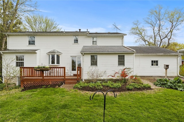 rear view of property featuring a lawn and a deck