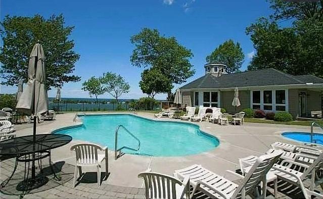 community pool with a patio and fence