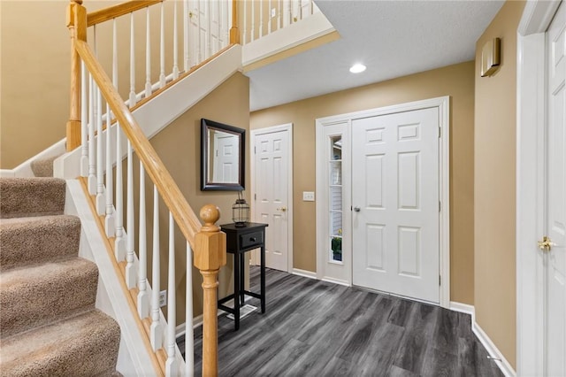 entrance foyer with recessed lighting, baseboards, stairway, and dark wood-style flooring