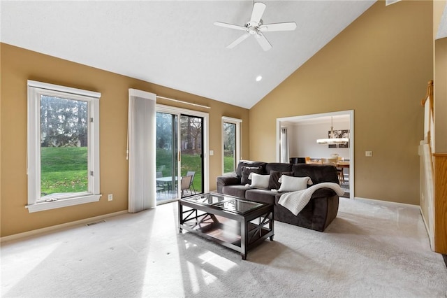 living area with visible vents, high vaulted ceiling, a healthy amount of sunlight, and light carpet