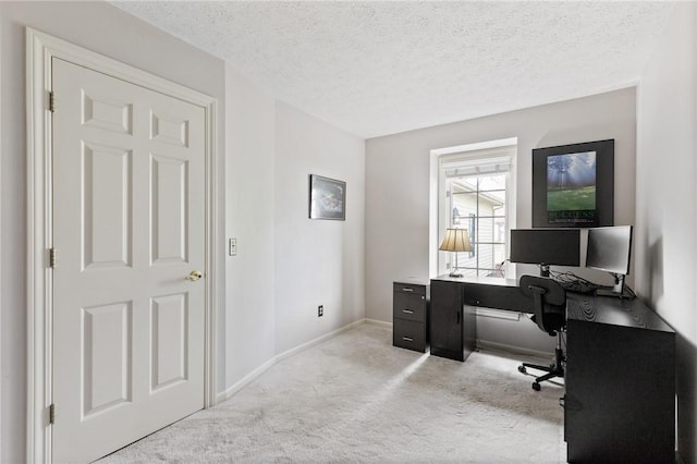carpeted office space featuring a textured ceiling and baseboards