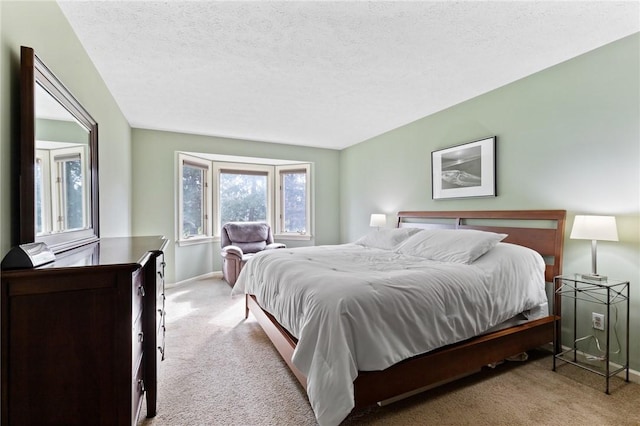 bedroom featuring carpet flooring, a textured ceiling, and baseboards