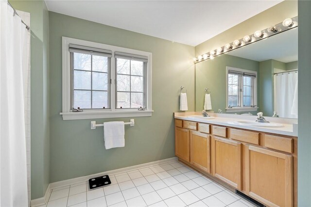full bathroom featuring double vanity, a sink, baseboards, and visible vents