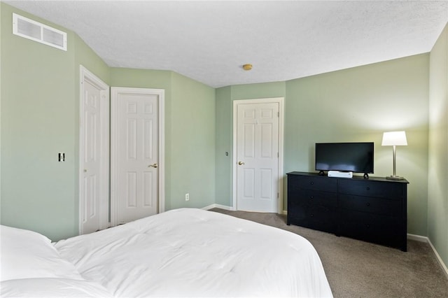 carpeted bedroom with baseboards and visible vents