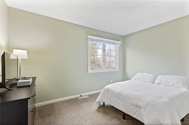carpeted bedroom featuring baseboards and visible vents
