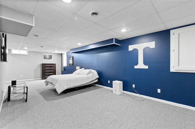 bedroom featuring baseboards, carpet flooring, a drop ceiling, and visible vents
