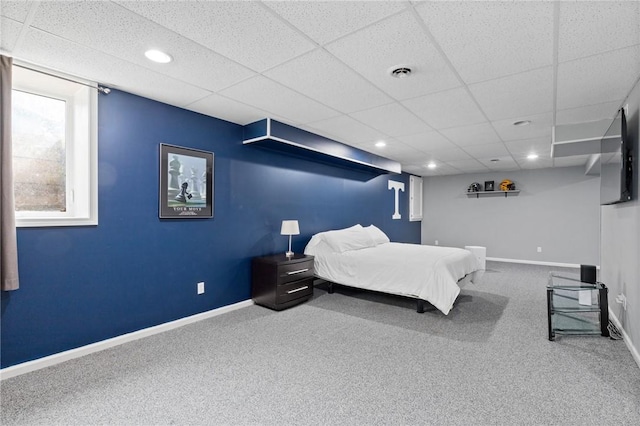 carpeted bedroom with baseboards, a drop ceiling, recessed lighting, and visible vents