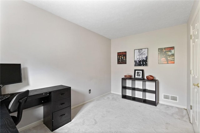 office area with visible vents, baseboards, and light colored carpet