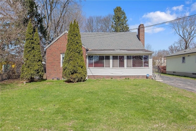 view of front of property with a front lawn, roof with shingles, and a chimney