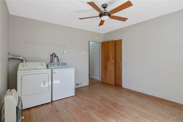 laundry area featuring laundry area, light wood finished floors, a ceiling fan, visible vents, and washer and clothes dryer