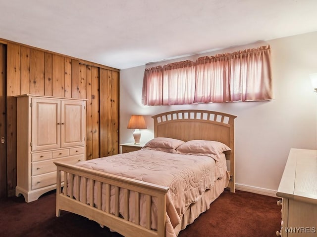 bedroom with baseboards and dark carpet