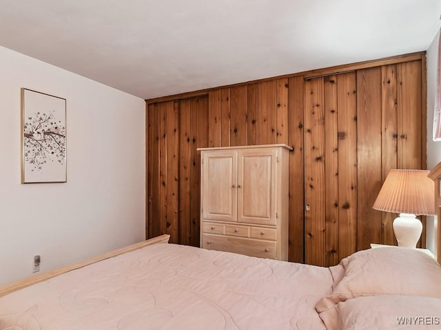 bedroom featuring wood walls