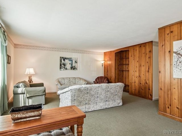 living room featuring carpet floors, wood walls, and baseboards
